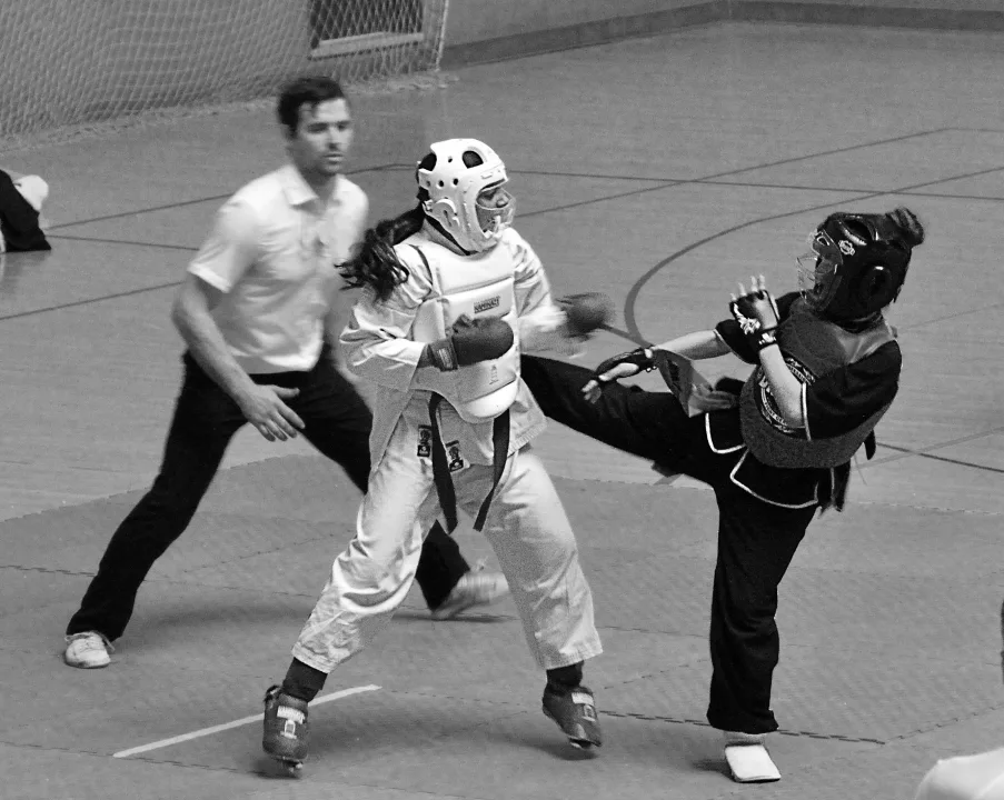 Patada durante un asalto de Sanda con casco y protecciones en competición