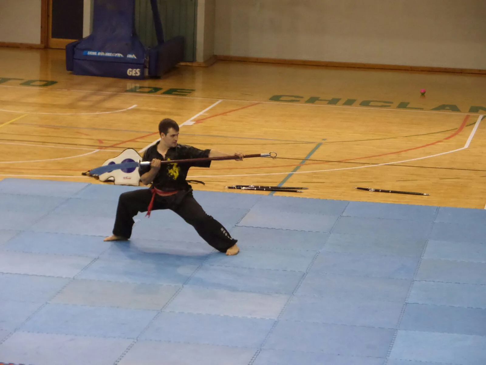 Alumno en postura de lanza durante una forma de wushu